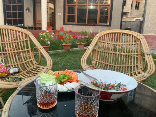 een tafel met twee stoelen en een kom eten erop bij Rabyang Guest House and Homestay in Leh