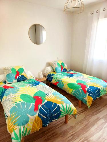 Cette chambre comprend 2 lits et un miroir. dans l'établissement Charmante villa dans un village paisible aux portes d'Uzès et des Cévennes, à Saint-Hippolyte-de-Caton