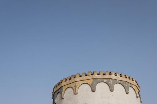 an old tower with a blue sky in the background at Club Azzurro Hotel & Resort in Porto Cesareo