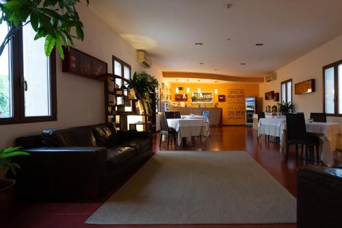a living room with a couch and a dining room at Club Azzurro Hotel & Resort in Porto Cesareo