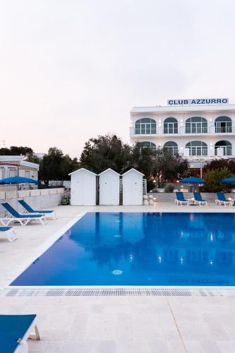 a large swimming pool in front of a building at Club Azzurro Hotel & Resort in Porto Cesareo