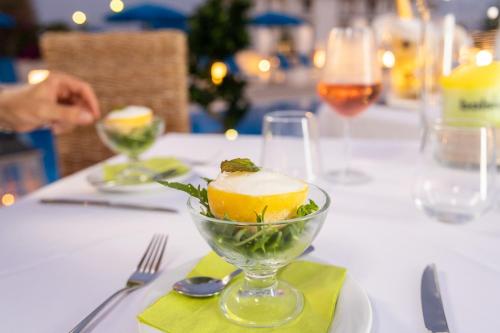 a table with a glass bowl with a dessert on it at Club Azzurro Hotel & Resort in Porto Cesareo