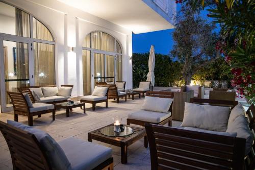 a patio with a bunch of chairs and tables at Club Azzurro Hotel & Resort in Porto Cesareo