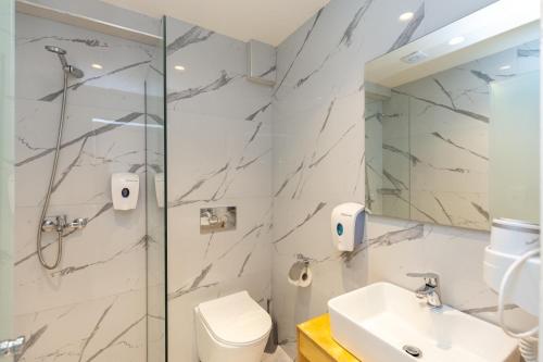 a bathroom with a shower and a toilet and a sink at Aqua Luxury Suites by Estia in Roda