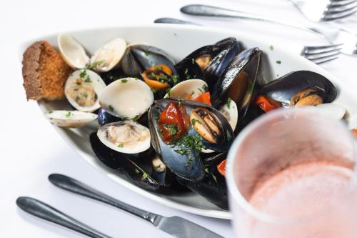a plate of mussels and bread on a table at Club Azzurro Hotel & Resort in Porto Cesareo