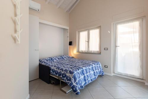 a bedroom with a bed and two windows at COME A CASA 19 - Romantic Studio in Massino Visconti