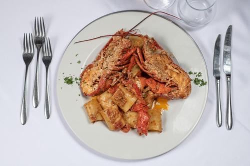 a plate of food with meat and french fries at Club Azzurro Hotel & Resort in Porto Cesareo