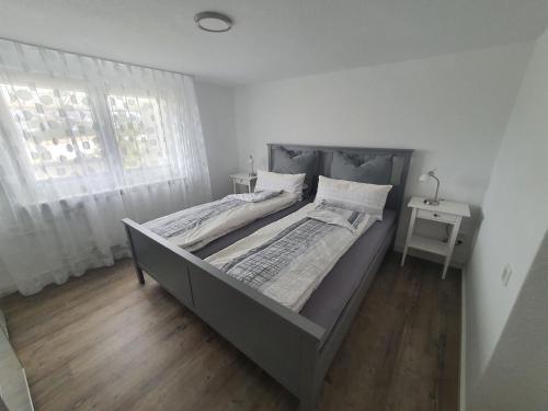 a large bed in a white room with a window at Ferienwohnung Haus Ruhrkopfblick in Winterberg