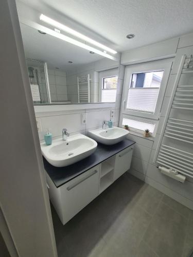 a bathroom with two sinks and a large mirror at Ferienwohnung Haus Ruhrkopfblick in Winterberg