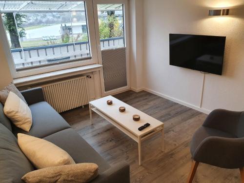 a living room with a couch and a tv at Ferienwohnung Haus Ruhrkopfblick in Winterberg