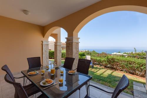 a dining room with a table and chairs on a patio at Aphrodite Hills Rentals - Apartments in Kouklia
