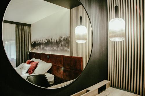 a mirror in a room with a couch and a chair at Bajka Hotel & Resort in Grodziec