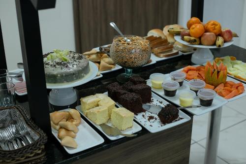 a buffet with different types of desserts and cakes at Royal Trip Hotel in Guarapuava