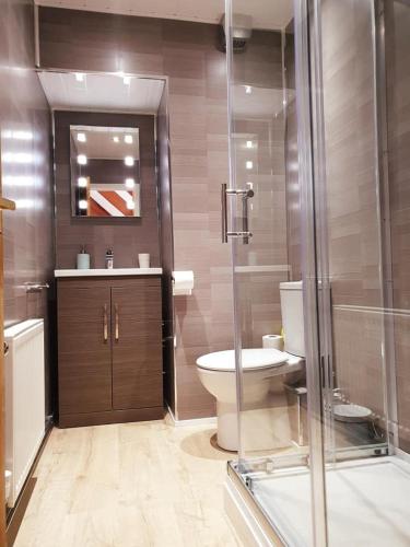 a bathroom with a toilet and a glass shower at Combe-n-Sea in Haverigg