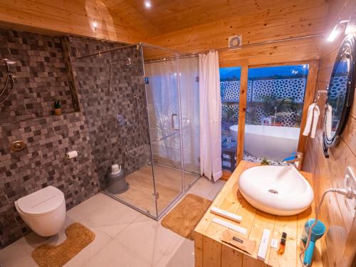 uma casa de banho com um chuveiro, um WC e um lavatório. em La Vita Nuova Resort & Spa em Shaugaon