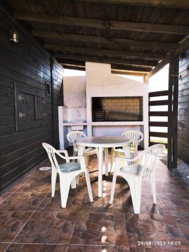 a patio with a table and chairs and a stove at Las Mozitas 1 in Barra del Chuy