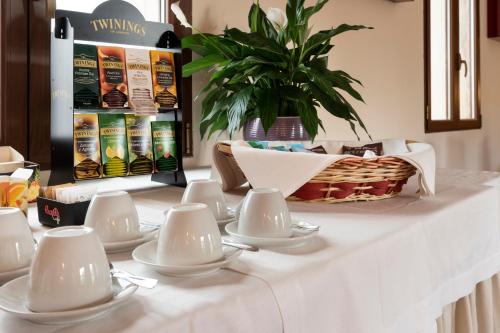 a table with white dishes and a basket on it at Club Azzurro Hotel & Resort in Porto Cesareo