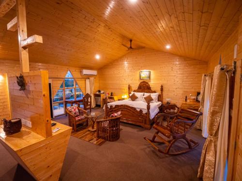 a bedroom with a bed and chairs in a room at La Vita Nuova Resort in Shaugaon