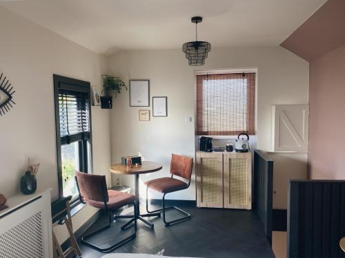 a kitchen with a table and chairs and a refrigerator at Kavel 90 in Den Burg
