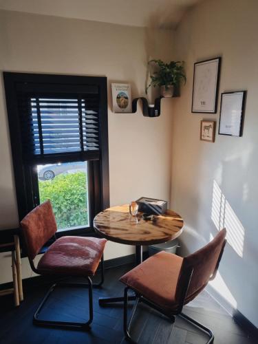 a room with a table and chairs and a window at Kavel 90 in Den Burg