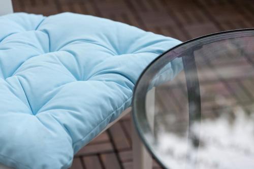 a blue couch with a blue blanket and a glass table at Club Azzurro Hotel & Resort in Porto Cesareo