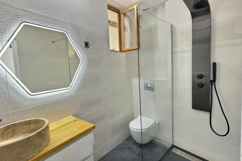 a bathroom with a sink and a toilet and a mirror at Des appartements au calme dans un immeuble historique in Béziers