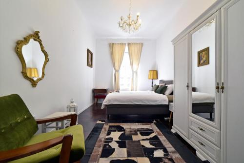 Un dormitorio con una cama, una silla y un espejo. en 1BR in central Zagreb & main station, free parking, en Zagreb