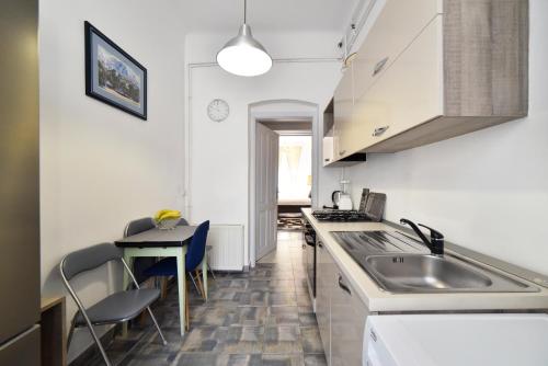 Una pequeña cocina con un fregadero y una mesa. en 1BR in central Zagreb & main station, free parking, en Zagreb