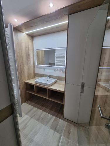 a bathroom with a sink and a mirror at Apartmán Nerudovka D 104, Finská sauna, garážové stání in Loučná pod Klínovcem