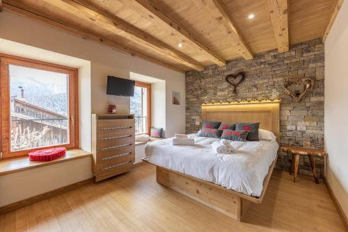 a bedroom with a bed and a stone wall at Casa Ladinia in San Vito di Cadore