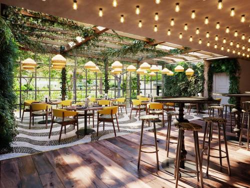 a restaurant with tables and chairs and plants at Holiday Inn The Hague - Voorburg, an IHG Hotel in Voorburg