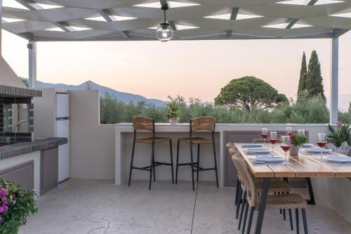 a patio with a table and chairs with a view at Daisy's Garden - Villa with Private Pool, Ideal for Large Groups, by ZanteWize in Dhrákas