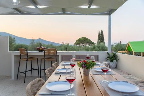 a table with glasses of wine on a patio at Daisy's Garden - Villa with Private Pool, Ideal for Large Groups, by ZanteWize in Dhrákas