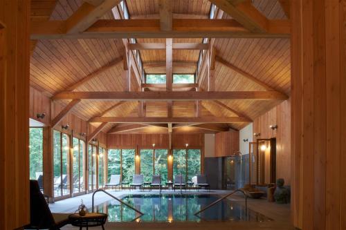 an indoor pool in a house with a wooden ceiling at Les Sources de Cheverny in Cheverny