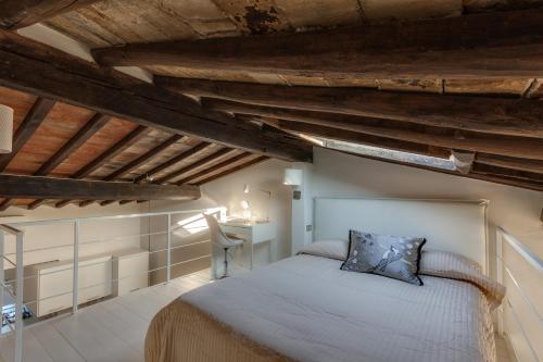 フィレンツェにあるApartments Florence Accademia Luxury Loftの木製の天井の客室で、ベッドルーム1室(ベッド1台付)