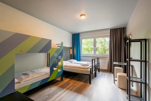 a room with two bunk beds and a window at a&o Berlin Kolumbus in Berlin