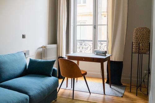 a living room with a couch and a table next to a window at Maison Manège Bordeaux Centre in Bordeaux