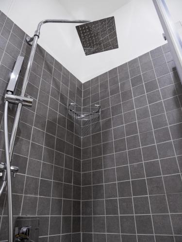 a bathroom with a shower with a tiled wall at Le Casette sul Mare - Case Vacanza in Cittadella del Capo