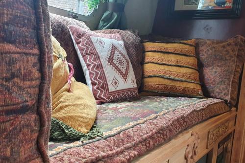 a couch with pillows on top of it at AirstreamNB in Schayk