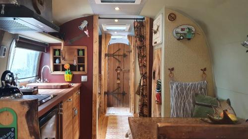 a kitchen with an archway and a kitchen with a door at AirstreamNB in Schayk