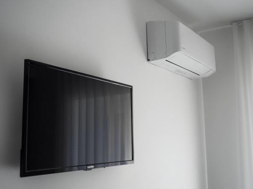 a flat screen tv hanging on a wall at Le Casette sul Mare - Case Vacanza in Cittadella del Capo