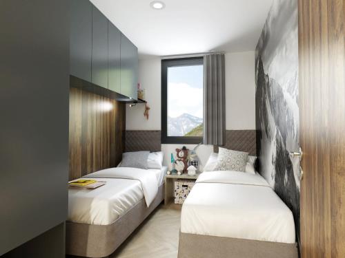 two beds in a room with a window at Chalets & Glamping Nassfeld by ALPS RESORTS in Kötschach