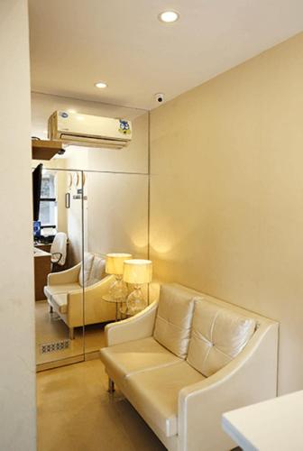 a living room with a white couch in a room at Capital Suites in Bengaluru