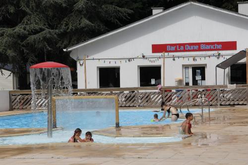 un grupo de niños jugando en una piscina en Entre sable et feuillus, en Camiers