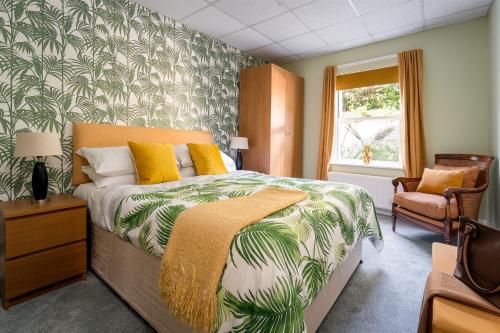 a bedroom with a bed with a tropical wallpaper at Palm Grove Apartments in Torquay