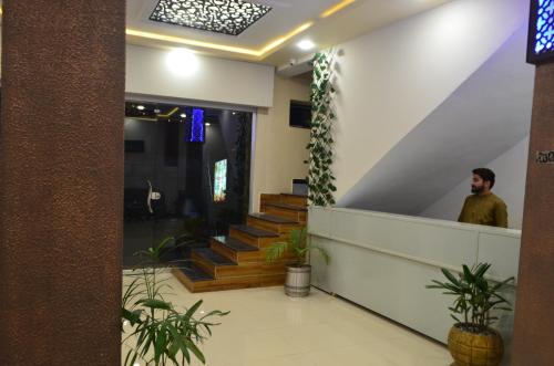 a man standing in the lobby of a building at Grand Holiday Hotel in Mingora