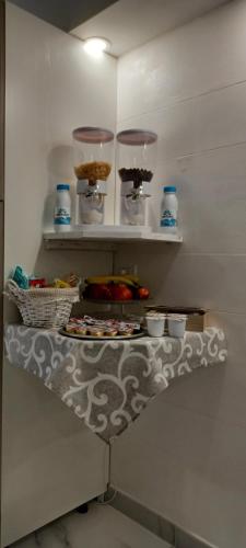 ein Regal mit Schüsseln und Tellern mit Essen darauf in der Unterkunft Corleone GUESTHOUSE in Corleone