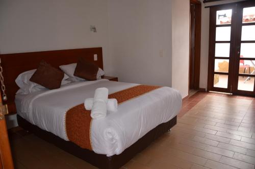 Postel nebo postele na pokoji v ubytování Hotel Santiago Diaz Piedrahita