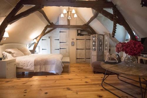 - une chambre avec un lit et une table fleurie dans l'établissement La ferme du coustal, à Vialot