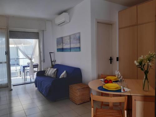 uma sala de estar com um sofá azul e uma mesa em La terrazza tra il Mare e gli Ulivi by Holiday World em Lavagna